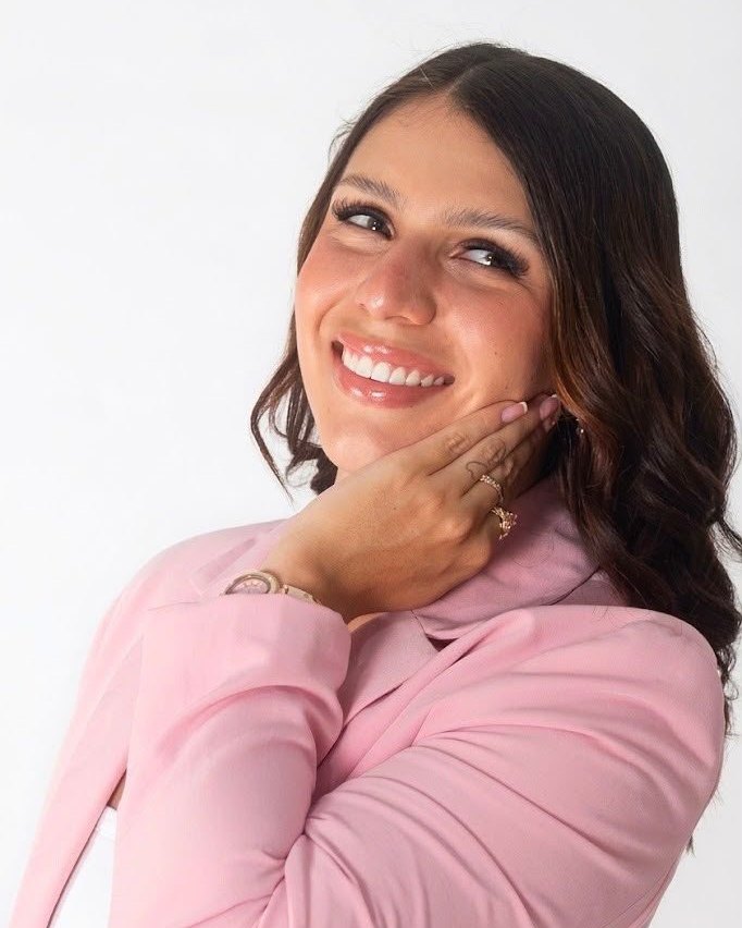 Kendolly Porras, fundadora de PinKempire, sonriendo con un blazer rosa